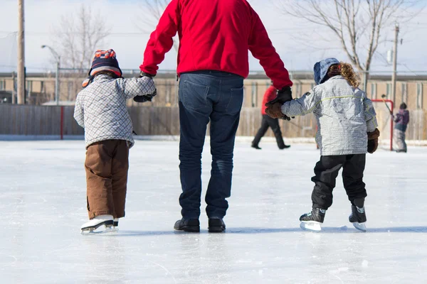 Familie hat Spaß auf der Eisbahn — Stockfoto