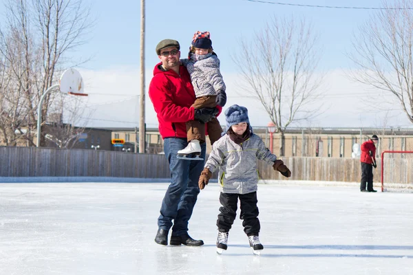 Gelukkige familie op de ijsbaan — Stockfoto