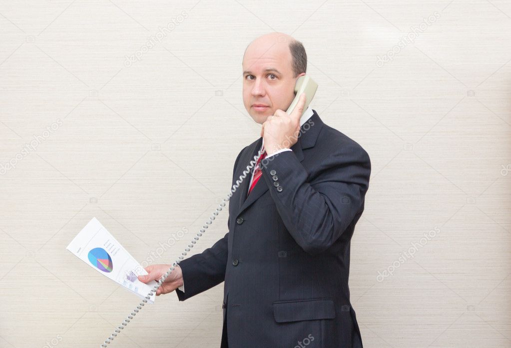 Business man with a document on the telephone