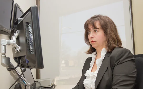 Γυναίκα των επιχειρήσεων κάθεται στο γραφείο, ψάχνει στο όργανο ελέγχου — Φωτογραφία Αρχείου