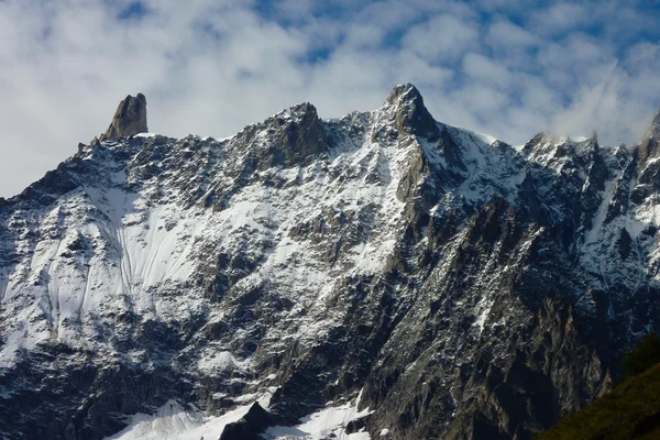 Rotsachtige bergruggen net kuste de sneeuw — Stockfoto