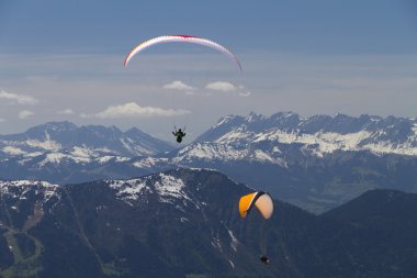 Paragliders over the mountains (red and orange) clipart
