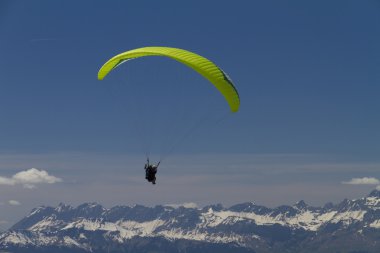 Paraglider over the mountains (green) clipart