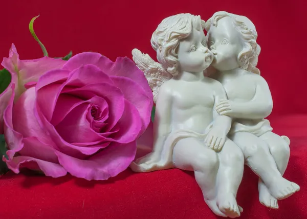 Angels kissing and pink rose — Stock Photo, Image