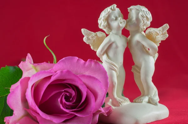 Angels kissing and pink rose — Stock Photo, Image