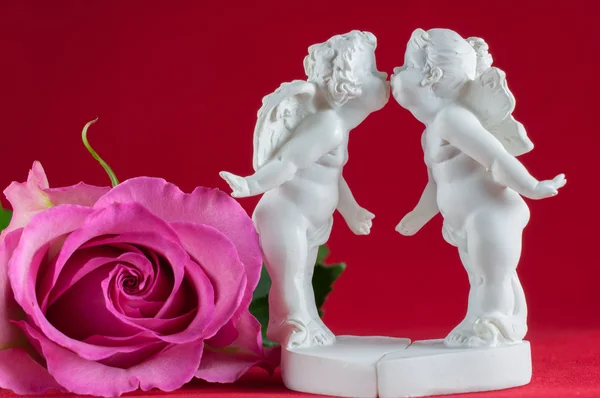 Ангелы целуются и розовая роза — стоковое фото
