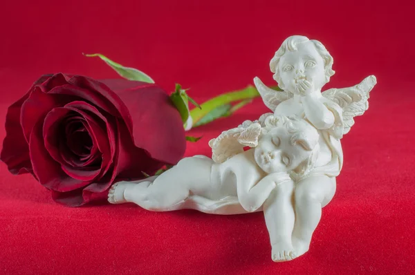 红玫瑰红色背景上的天使 — 图库照片