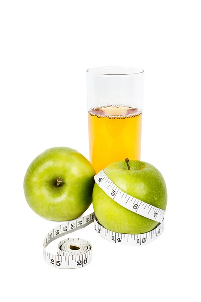 Mele verdi con nastro di misurazione con bicchiere di succo di mela — Foto Stock