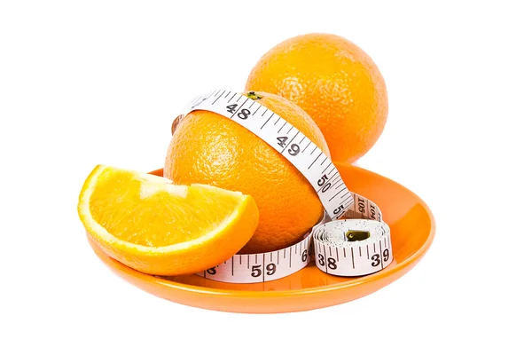 Oranges in measuring tape on plate — Stock Photo, Image