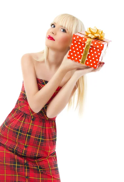 Beautiful young blonde girl holding christmas gift in red dress — Stock Photo, Image