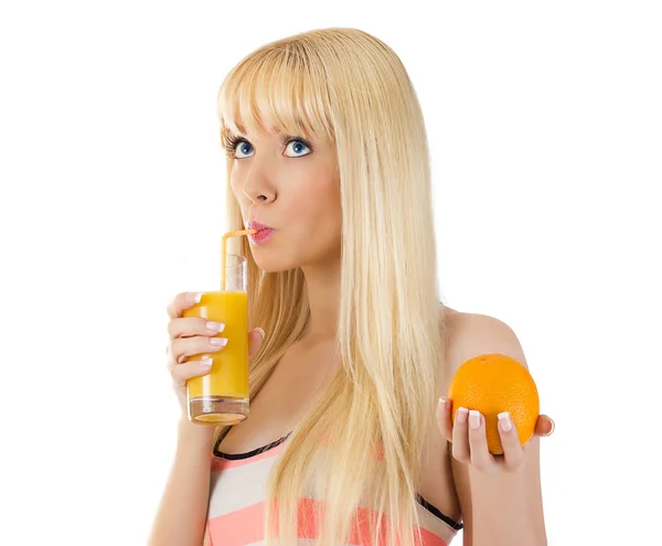 Ładna kobieta trzymając pomarańczowe popijając szklanką soku — Zdjęcie stockowe