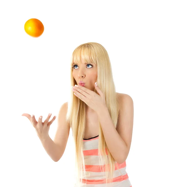 Frau wirft eine Orange in die Luft — Stockfoto