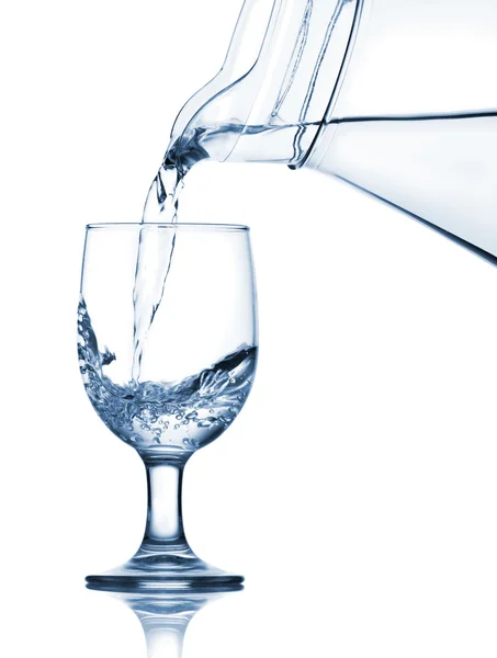 Наливание воды в стакан из кувшина — стоковое фото