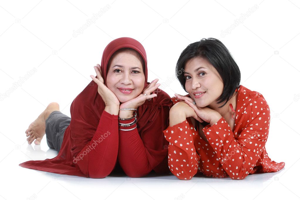 Muslim woman with her daughter lying