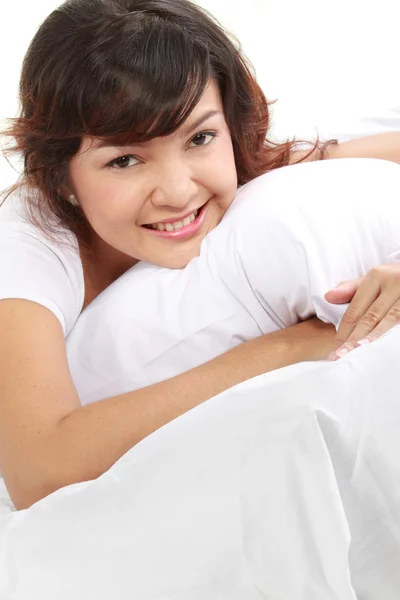 Mladá žena leží na posteli — Stock fotografie