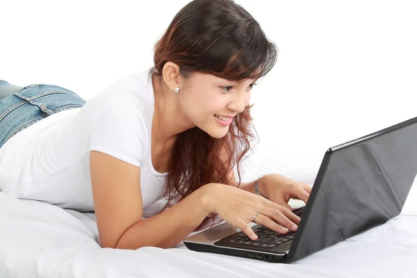 Женщина с ноутбуком на кровати — стоковое фото
