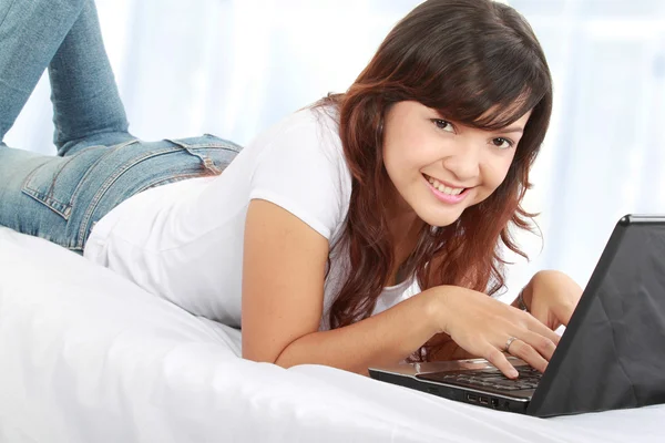Γυναίκα με φορητό υπολογιστή στο κρεβάτι — Φωτογραφία Αρχείου