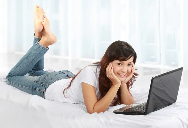Žena s laptopem na posteli — Stock fotografie