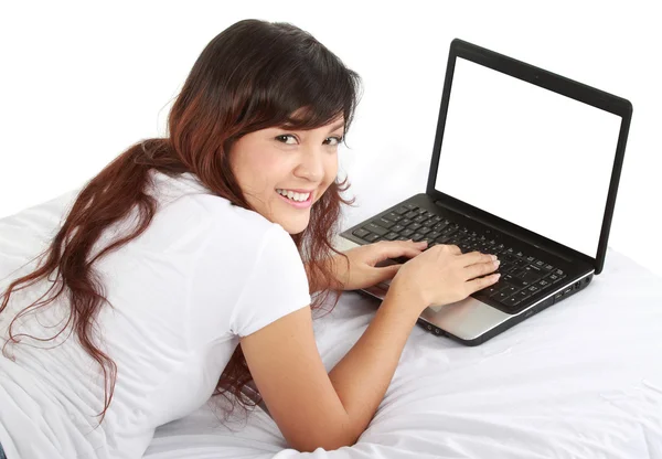 Menina deitada na cama com laptop — Fotografia de Stock