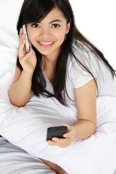 Mujer teniendo una llamada telefónica mientras envía un mensaje de texto — Foto de Stock