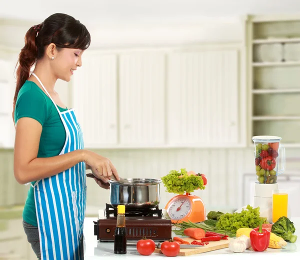 Vrouw kookt in de keuken — Stockfoto