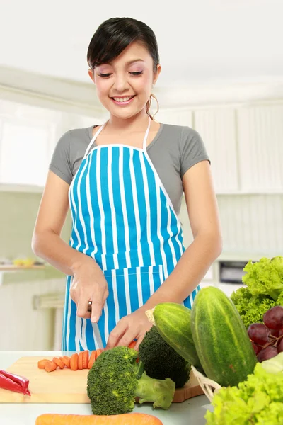 Vrouw die groenten snijdt in de keuken — Stockfoto