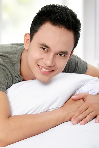 Hombre acostado en la cama sonriendo — Foto de Stock