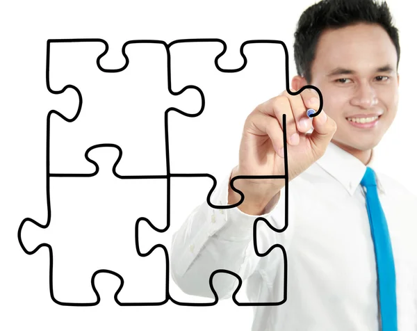 Businessman drawing puzzle — Stock Photo, Image