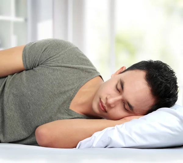 Мужчина лежит в постели и спит — стоковое фото