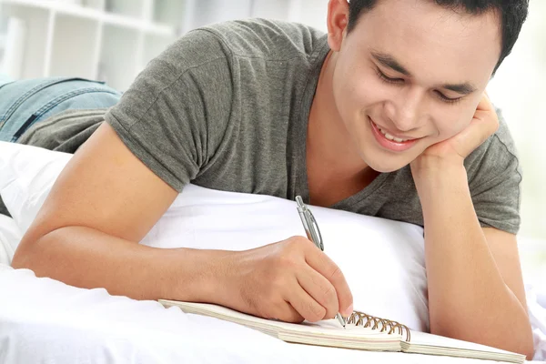 Asiatique mâle écriture sur notepad — Photo