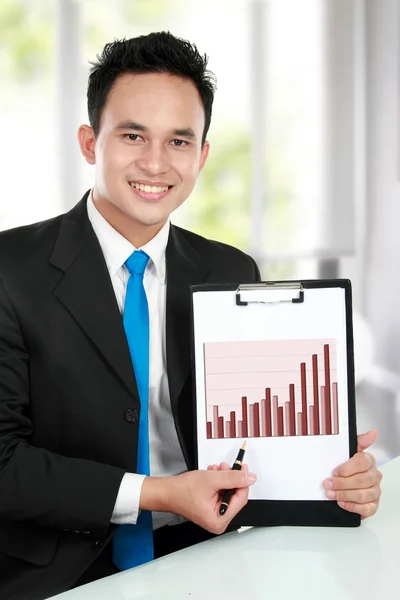 Jovem homem de negócios mostrando gráfico de crescimento — Fotografia de Stock