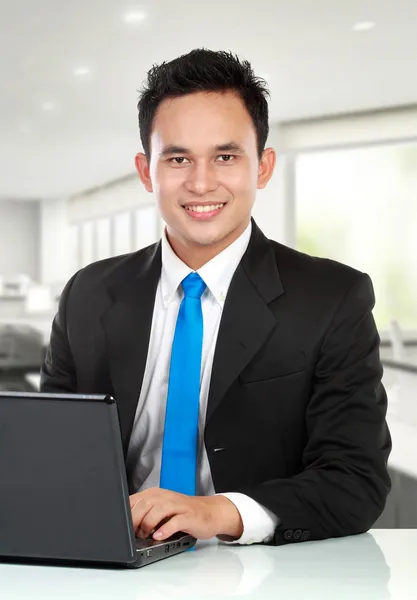 Jovem homem de negócios com um laptop — Fotografia de Stock
