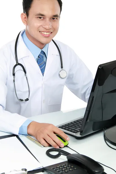 Доктор за своїм столом перед комп'ютером — стокове фото