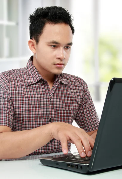 Seriöser Mann arbeitet mit Laptop am Schreibtisch — Stockfoto