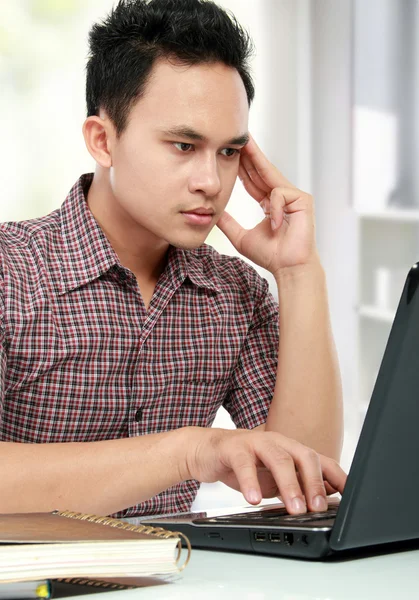 Koncentrera man som arbetar med laptop vid sitt skrivbord — Stockfoto