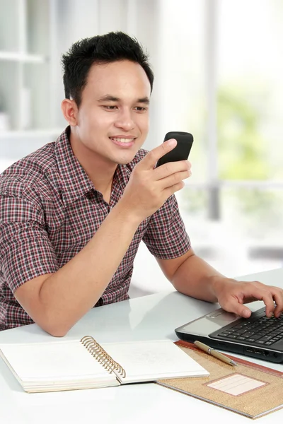 남자는 노트북 및 문자 메시지를 사용 하 여 휴대 전화에 — 스톡 사진