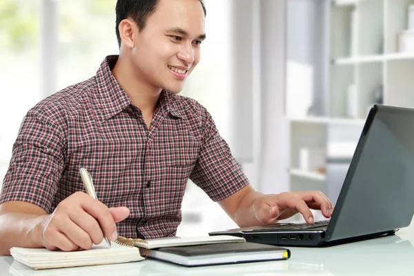 Man som arbetar med laptop vid sitt skrivbord — Stockfoto