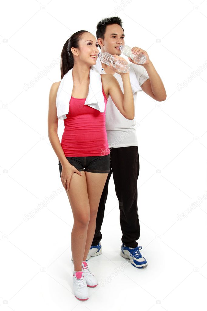Man and woman drinking water after fitness