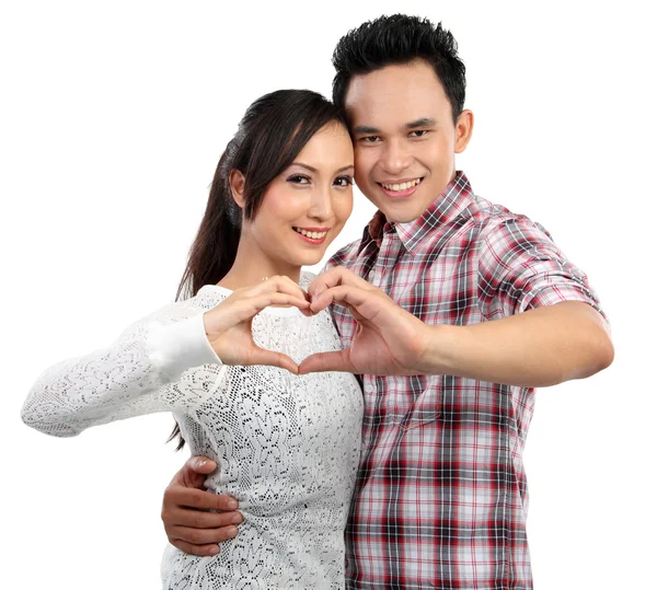 Jovem casal apaixonado mostrando coração com os dedos — Fotografia de Stock