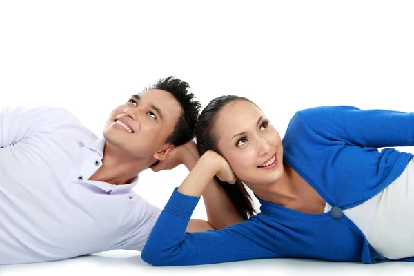 Couple lying on the floor looking up to copy space — Stock Photo, Image