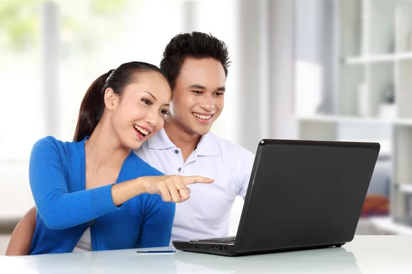 Casal sorrindo usando um laptop — Fotografia de Stock