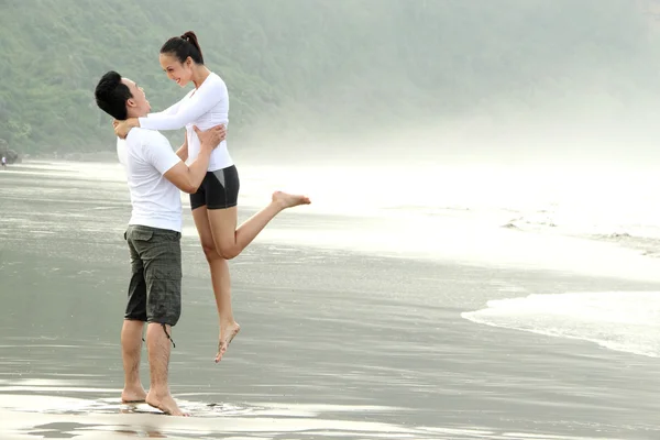 Para bawiąca się na plaży — Zdjęcie stockowe