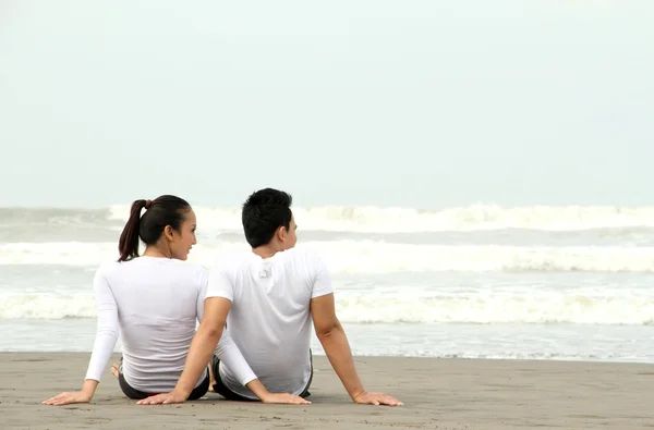 坐在海滩上的情侣 — 图库照片