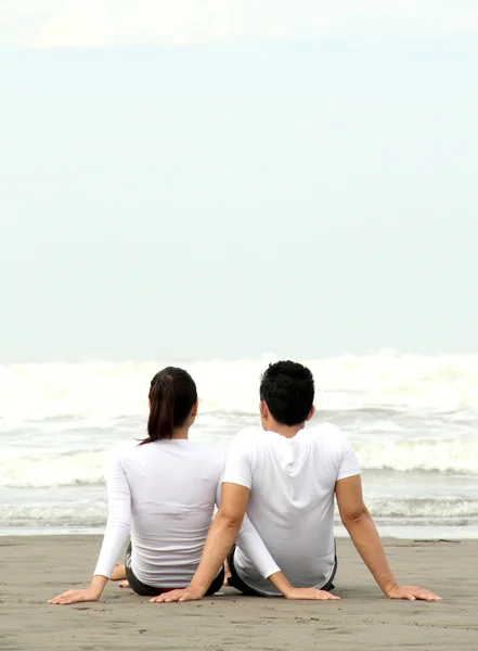 Paret sitter på stranden — Stockfoto