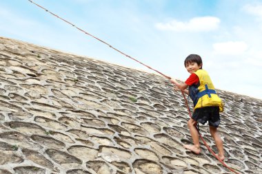 Kid climbing using rope clipart