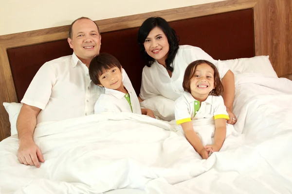 Gelukkige familie in het bed — Stockfoto