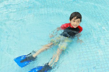 Havuzda yüzen çocuk.