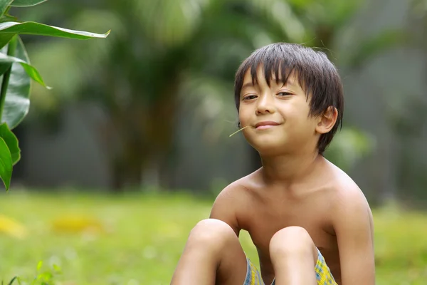 Boy sitting in the park — Stock Photo, Image
