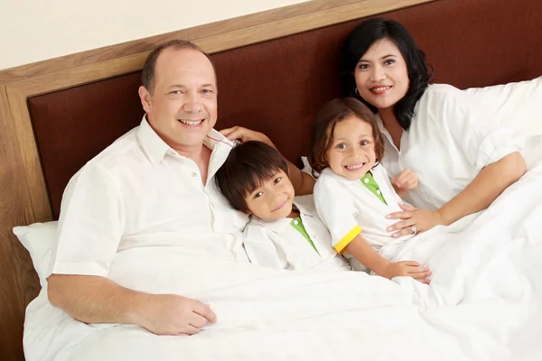 Счастливая семья в спальне — стоковое фото