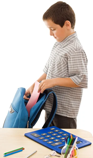 Schüler steckt ein Schulheft in die Schultasche — Stockfoto